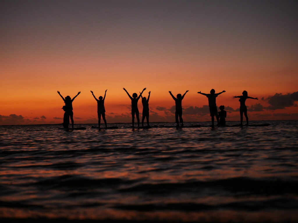 stand up paddle boards yoga practice group sunset silhouette