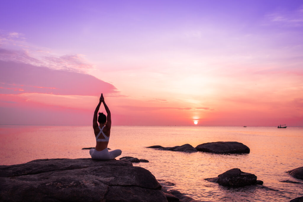 Asian girl practice Yoga on the beach Sunrise morning day